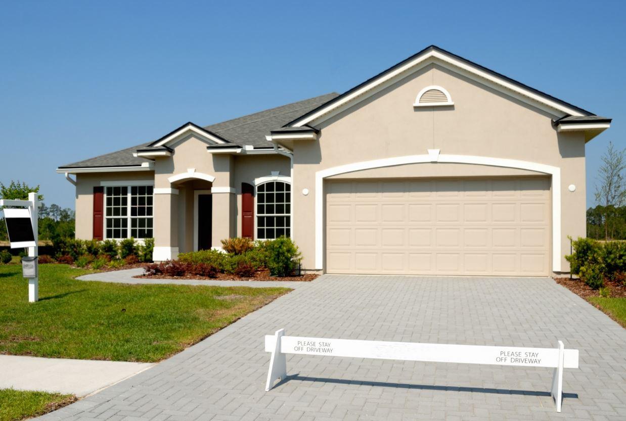 A newly built Florida stucco home with a paver driveway
